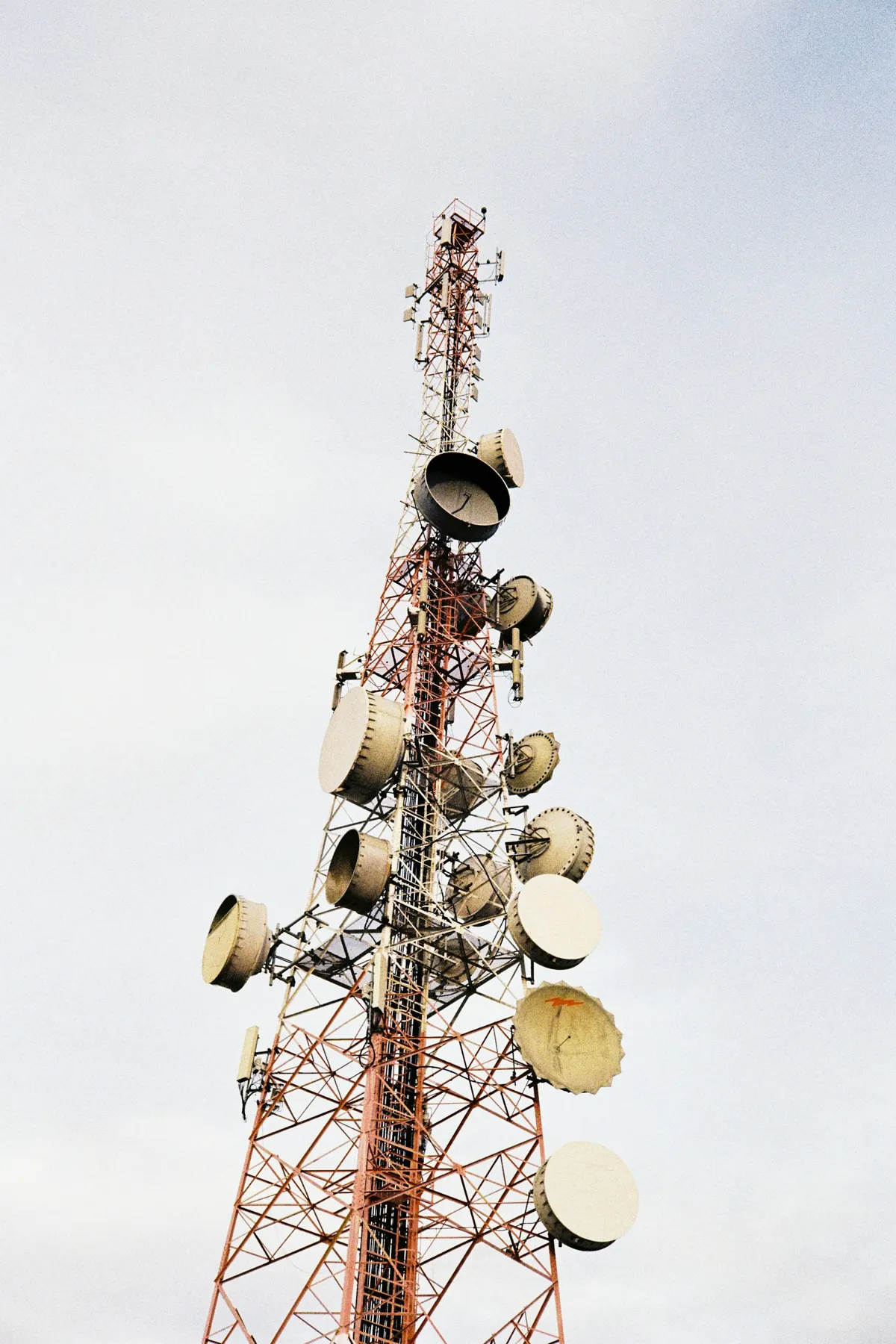 Red and white cell tower with microwave dishes in Sungai Petani, Kedah